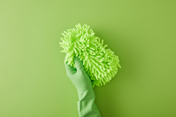 top view of housekeeper in rubber glove holding rag on green