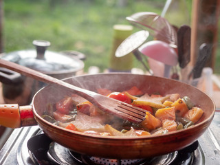 Cooking stewed vegetables in a pan. Pineapple, cannon, asparagus.