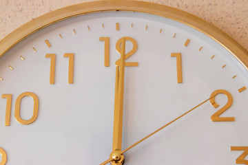 Wall clock in golden color. Dial and hands.