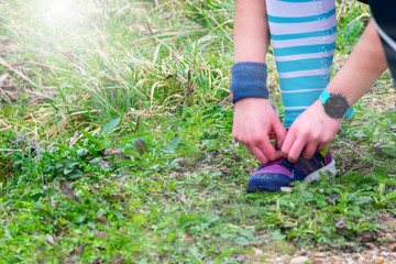 mountain racing athlete adjusting footwear with both hands