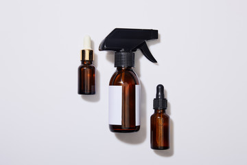 Top view of dispenser cosmetic bottles of oil on grey background