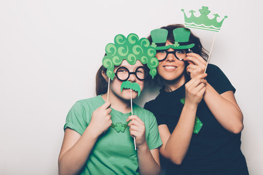 Young girl and a woman are preparing for the St Patricks Day party with photo booth props, Ireland traditional holiday, 17 March