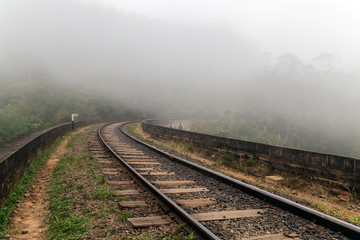 Fototapeta na wymiar Railroad Tracks in the Fog Demodara in Sri Lanka