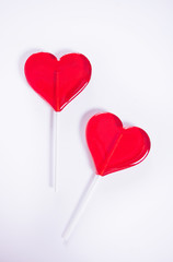 Fototapeta na wymiar Two red heart shaped lollipops candy for Valentines day. Top view. Copy space.