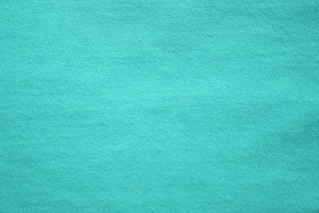 Texture background of empty azure fabric. Light blue canvas of soft material surface, blank plain wallpaper. Simple casual cloth t-shirt pattern, flat lay close up view 