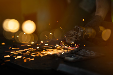 Work at the Heavy Industry Manufacturing Facility concept.Heavy industry worker cutting steel in workshop.bokeh light.