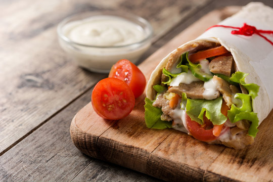 Doner kebab or shawarma sandwich on wooden table
