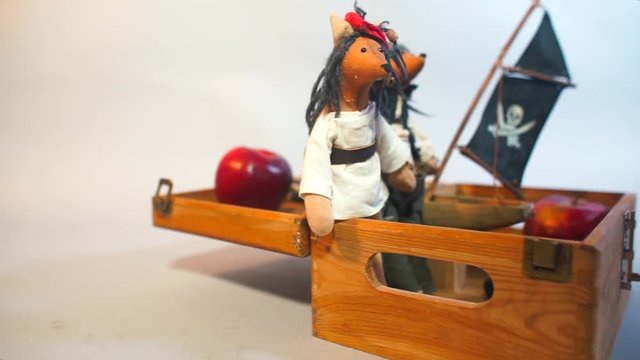 Dolls pirates are sitting on a wooden box.