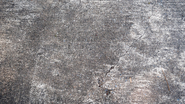 Black cement floor with longitudinal cracks
