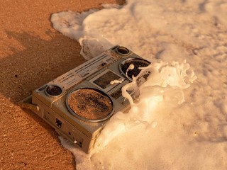Tape recorder in sea foam and waves.