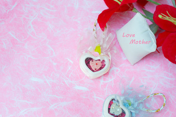 Happy Mother's day concepts. Mother's day and Sweetest day, love concept. Red flower with the letter Love Mother on white pillow. copy space for text.