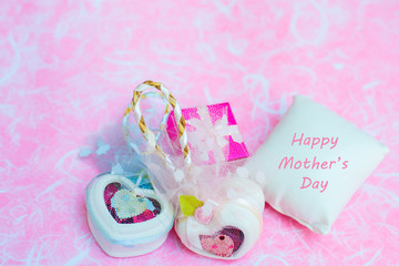 Happy Mother's day concepts. Mother's day and Sweetest day, love concept. White heart boxes with the letter Happy Mother's day on white pillow. copy space for text.