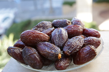 dried dates in a plate in the soft blur background. Close-up