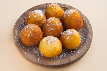 French doughnuts Beignet covered with sugar powder on a brown background