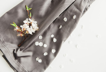 White blossom flowers on the  grey silk fabric background.Elegant feminine style.White backdrop.