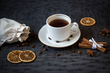 Fruit cake and a cup of coffee on a black table.