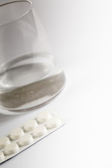 Fototapeta na wymiar Pills capsules medicine and glass of water on white background