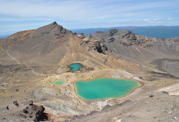 Awesome view of the vulcanic green lakes on the alpine mountain in the Tongariro National Park, hikers Walking down the track 