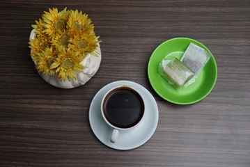 a cup of brewed black coffee and a piece of layer cake.