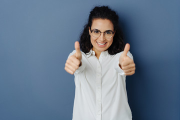 Exultant young woman giving a double thumbs up