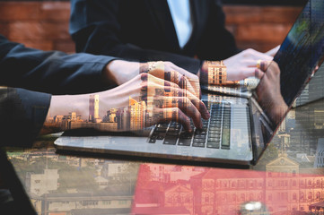 Double Exposure business man hands typing on a laptop