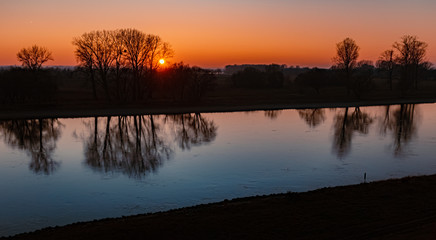 Obraz premium Beautiful sunset with reflections at the river danube near Winzer, Bavaria, Germany