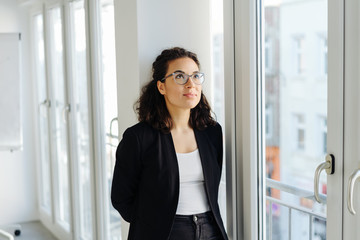 Young businesswoman standing thinking