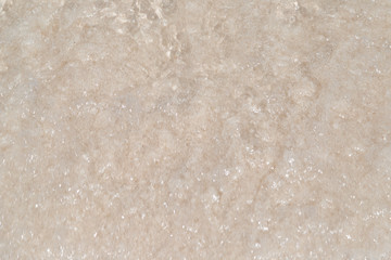 Top view of sea water on the clean white sand from wave ripple