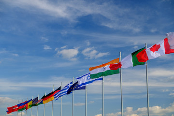 national flags of various countries flying in the wind. sky