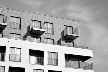 Detail of modern residential flat apartment building exterior. Fragment of new luxury house and home complex. Black and white.