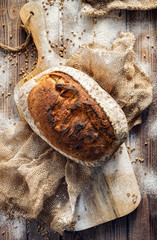 Bread, wheat and rye traditional sourdough bread on a wooden board, top view. Traditional, healthy food
