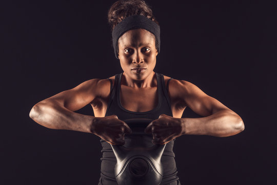 Junge afrikanische Sportlerin trainiert mit Kettlebell-Hantel.