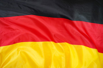 Fabric texture flag of Germany. Flag of Germany waving in the wind. Germany flag is depicted on a sports cloth fabric with many folds. Sport team banner.