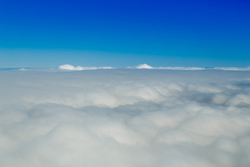 Naklejka premium Flying above the clouds in clear weather at a great height.