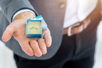 Close up opened engagement ring box on male hand. Wedding proposal relationship concept.