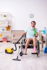 Young man in wheel-chair cleaning the house