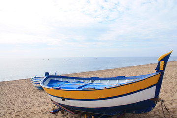 Naklejka premium Traditionals wooden boats in Callela beach, a seaside city on the Costa del Maresme, in the northeast of Barcelona, in Catalonia, Spain