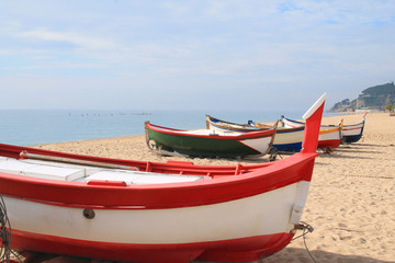 Fototapeta na wymiar Traditionals wooden boats in Callela beach, a seaside city on the Costa del Maresme, in the northeast of Barcelona, in Catalonia, Spain