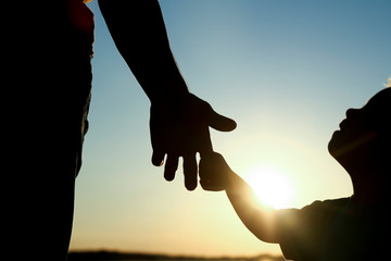 silhouette the parent holds the hand of a child