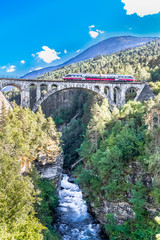 Fototapeta premium VERMA, NORWAY - 2018 AUGUST 01. Kylling bridge with the river below and train on the top.