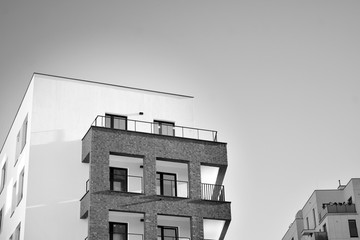 Detail of modern residential flat apartment building exterior. Fragment of new luxury house and home complex. Black and white.