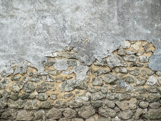 wall of large exposed stones covered with a layer of grey concrete