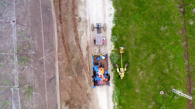 Ripe Bananas packed in blue plastic bags loaded on a Tracor trailer, Aerial view.