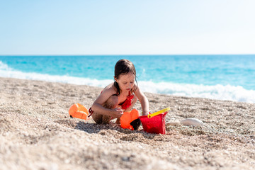 Little girl is playing on the beach