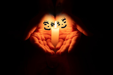 hands in the form of people look at the candle flame.concept of love, tenderness, warmth, date
