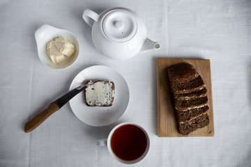 Whole grain bread on a white plate, healthy breakfast.
