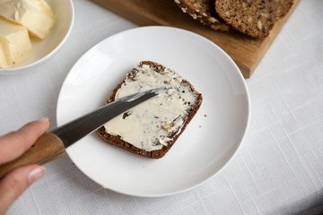 Whole grain bread on a white plate, healthy breakfast.