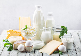 Fresh dairy products, milk, cottage cheese, eggs, yogurt, sour cream and butter on wooden table