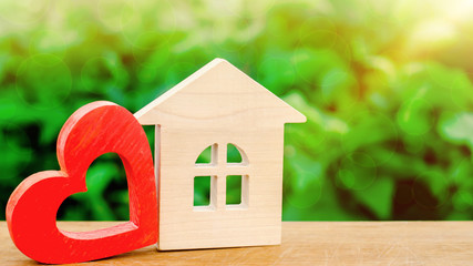 Wooden house and red heart. Concept of sweet home. Property insurance. A new home for family. Rent...