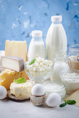 Fresh dairy products, milk, cottage cheese, eggs, yogurt, sour cream and butter on blue background